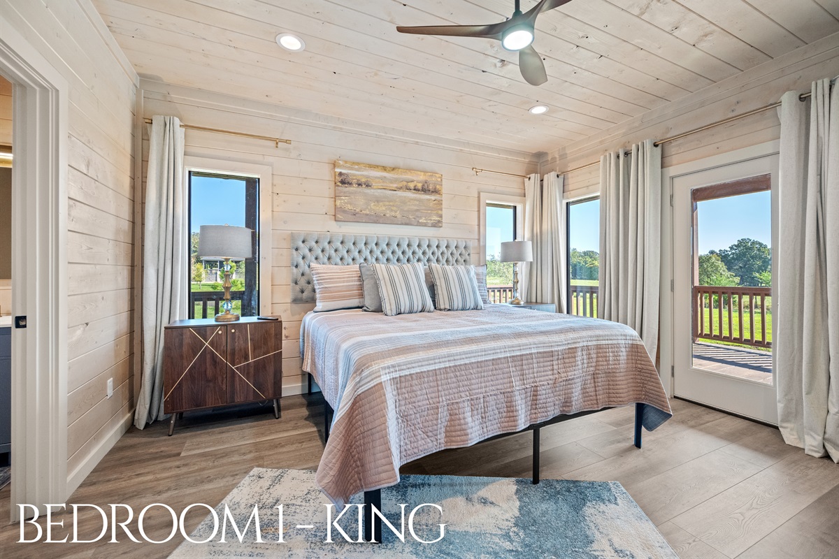 Bedroom 1 with king bed, natural light, and private access to the outdoors.