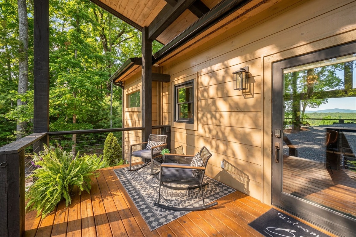 Rocking chairs, tall trees, and timeless tranquility at the front porch. A peaceful atmosphere.
