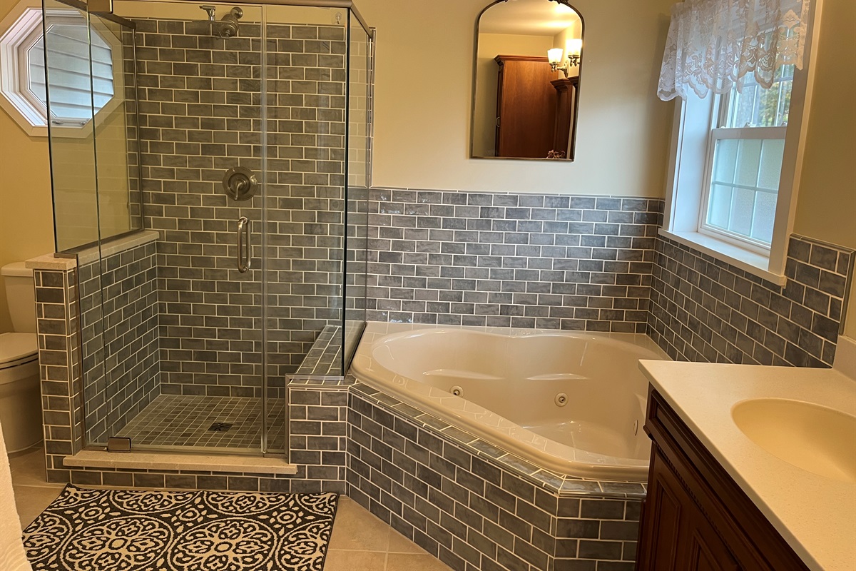 Primary bath with jetted tub and frameless glass shower