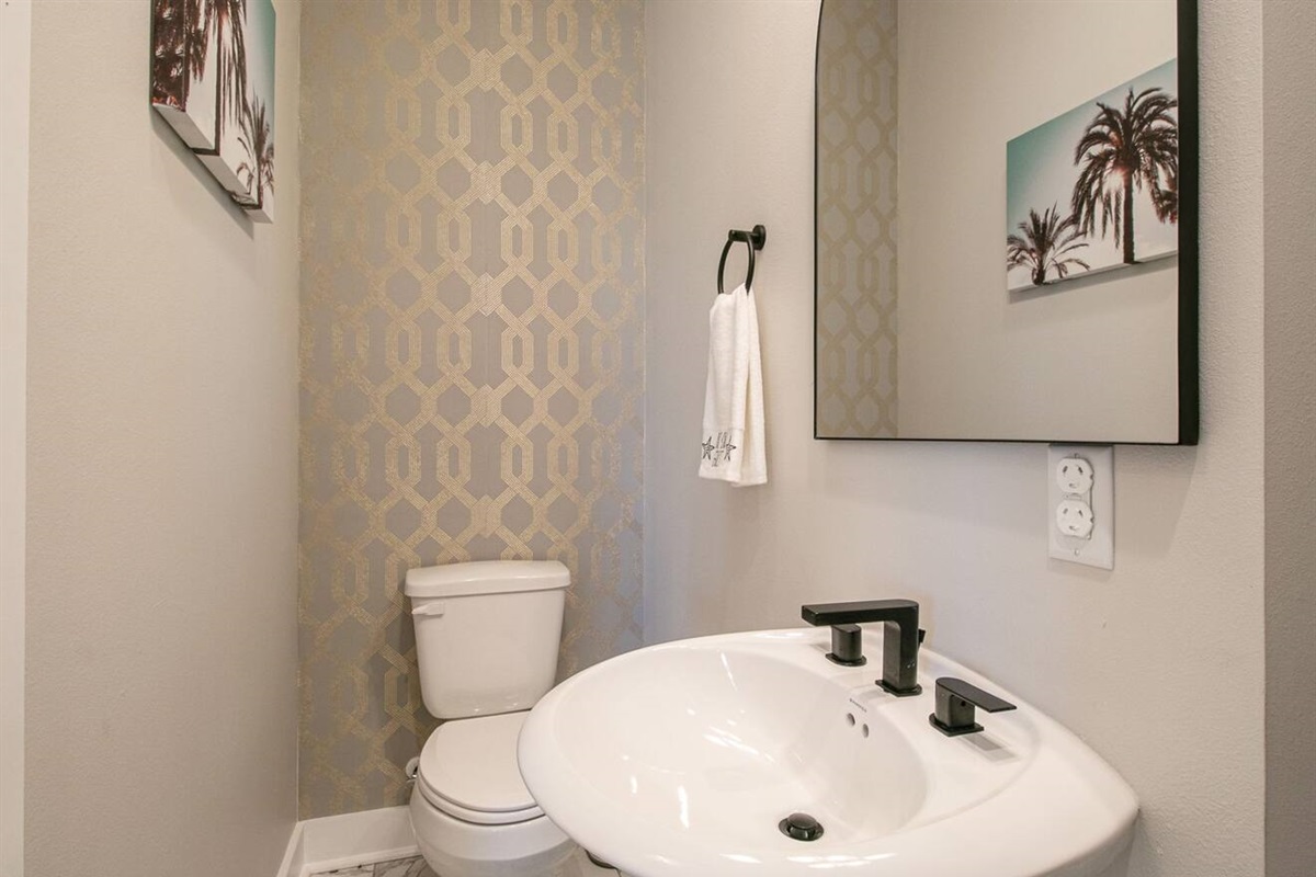 "Stylish Convenience: Half Bathroom with Striking Accent Wall - Perfect for a Quick Refresh and Conveniently Located for Your Comfort"
