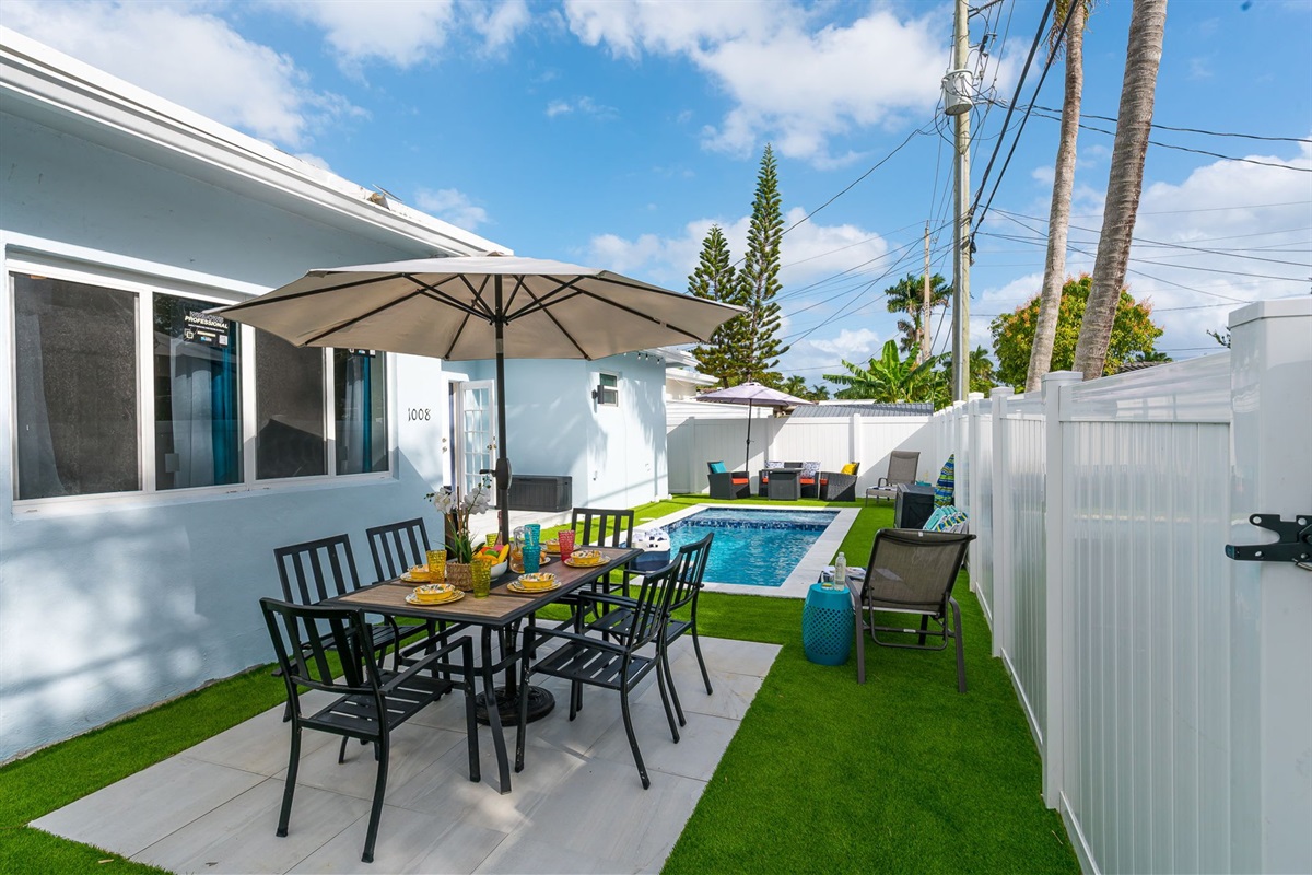 Enjoy al fresco dining by your private heated pool in this sunny Florida backyard, complete with vibrant outdoor seating and lush tropical vibes.