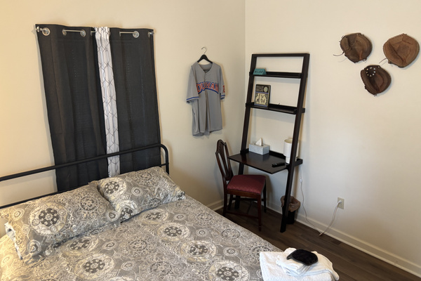 The queen bedroom includes a compact laptop desk and vintage Durham Bulls touches.