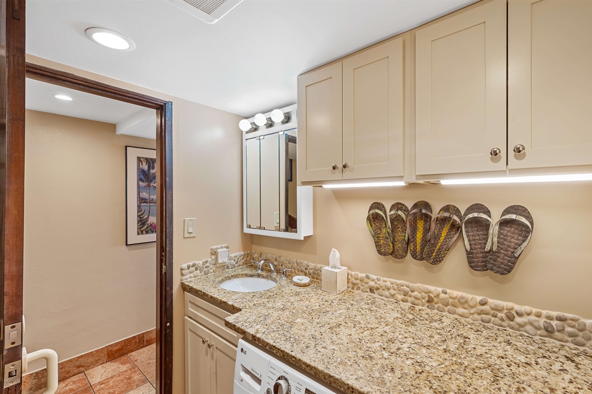 Main floor bathroom with shower, toilet, sink and washer/dryer