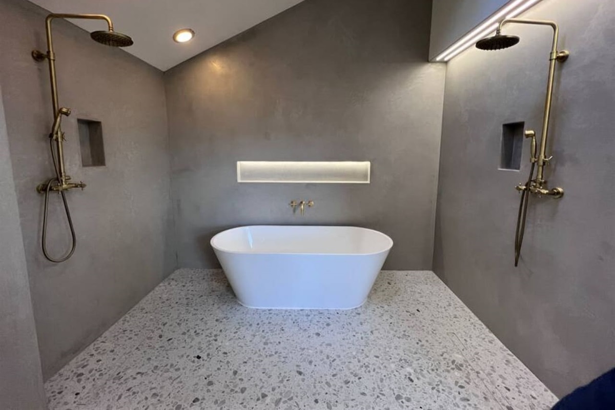 The primary suite has a new 120 sq ft private bathroom that is done in Moroccan plaster (walls) and Italian terrazzo (floors). It includes this 71" soaking tub and two showerheads, and a double faucet vanity.