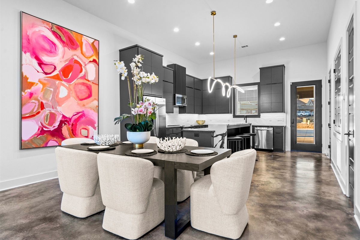 The dining area stands out with its bold artwork and clean, contemporary lines, offering a stylish and lively space for hosting family and friends.