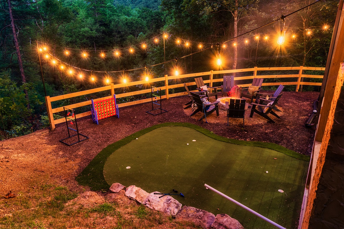Backyard with fire pit, mini golf, string lights & outdoor games