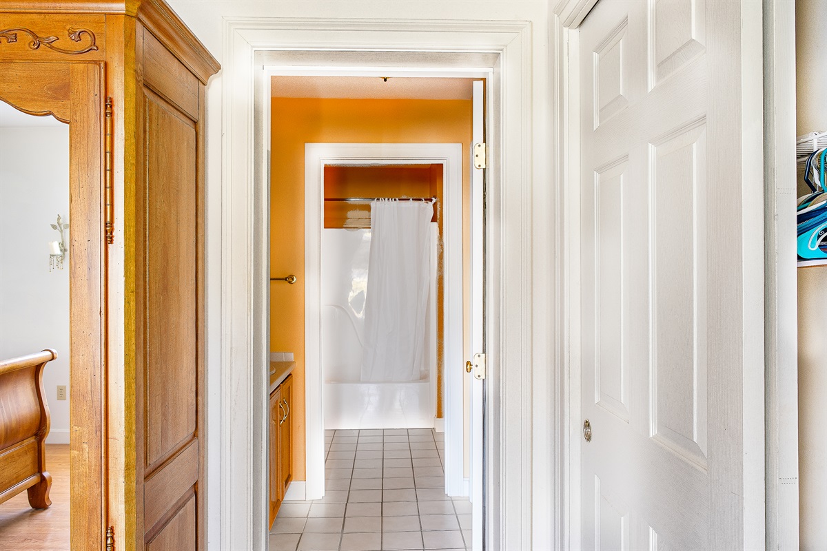 The Primary Suite features a two-room en suite bathroom for added privacy. The first room offers a dual vanity and large closet, leading into a separate space with a full tub/shower combo—a perfect setup for your Mount Desert Island retreat.