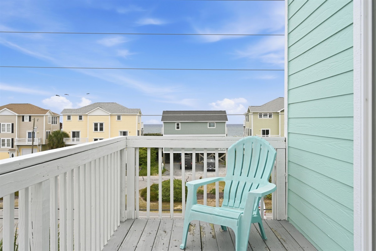 Balcony seating with partial ocean view between homes
