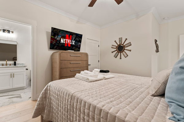 Queen size bed, walk in closet, attached bathroom, view of the front yard.