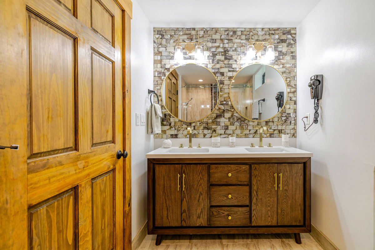 Beautiful lower-level bathroom offers a double vanity and modern finishes.