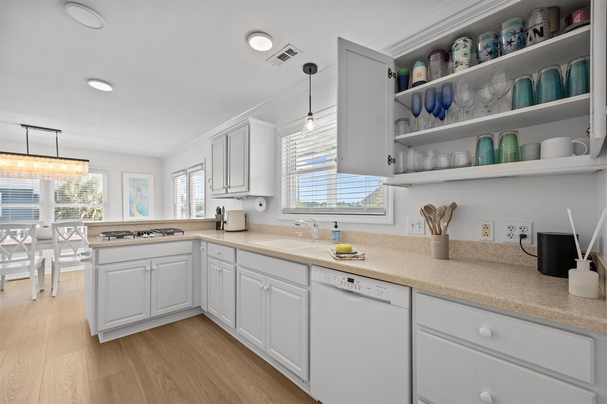 Fully stocked kitchen with glassware, cookware, and plenty of space to prepare meals