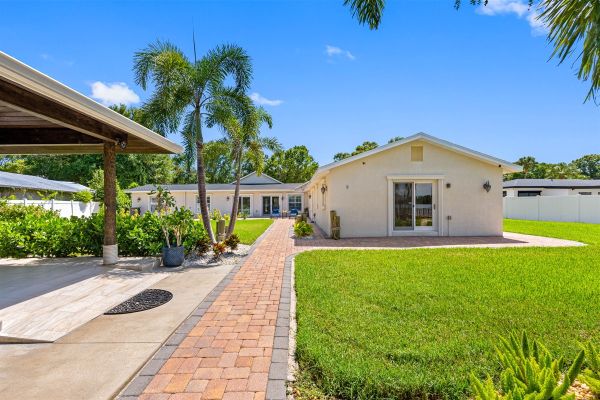 The combination of pavers, stone accents, and hardy tropical plants ensures a stylish yet easy-to-care-for outdoor space.