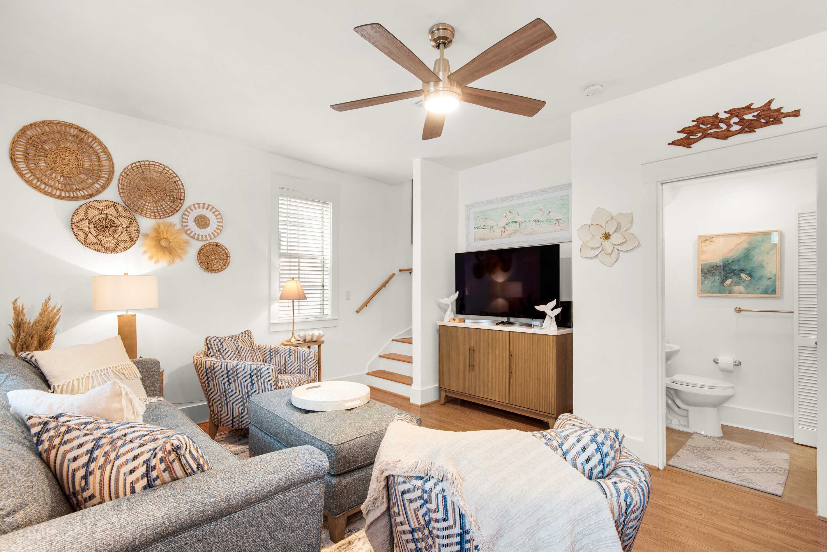 Seagrove Bungalow 103 living room with sectional seating, a television and coastal decor.