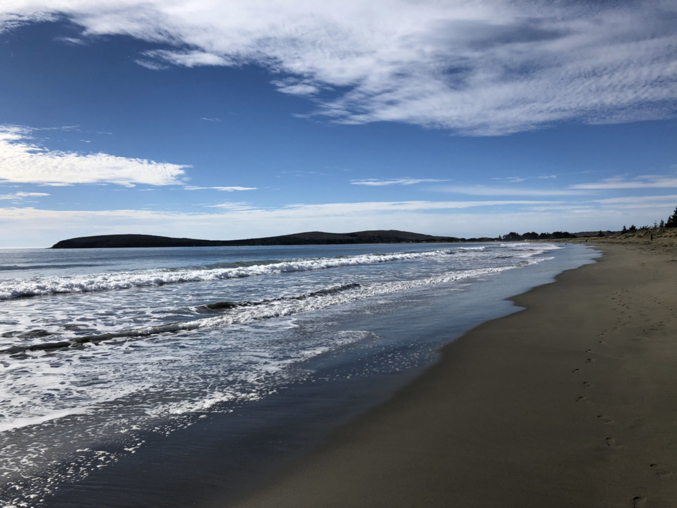 Gentle waves along a sunlit stretch of sandy beach