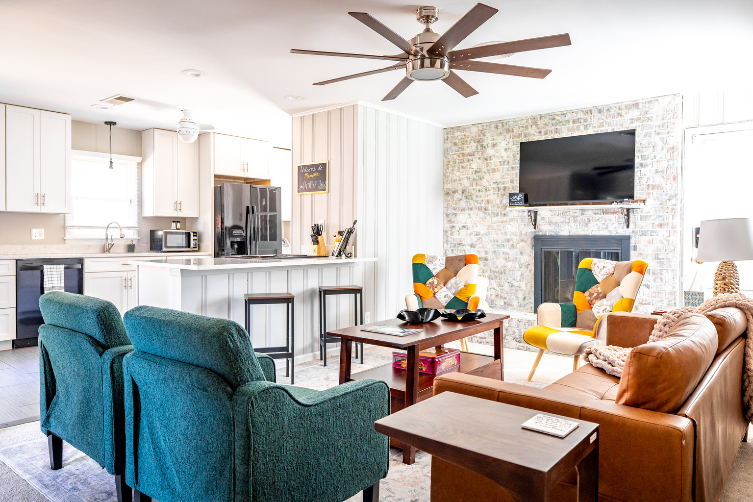 Living room that opens to the kitchen. Plenty of seating, decorative fireplace, TV