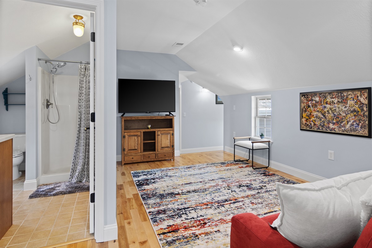 Relax upstairs with a sofa, TV, and cozy space to unwind.