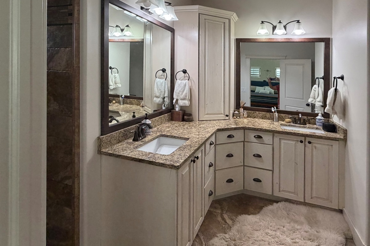 Spa-inspired primary bathroom with dual vanities, granite countertops, and upscale finishes throughout.