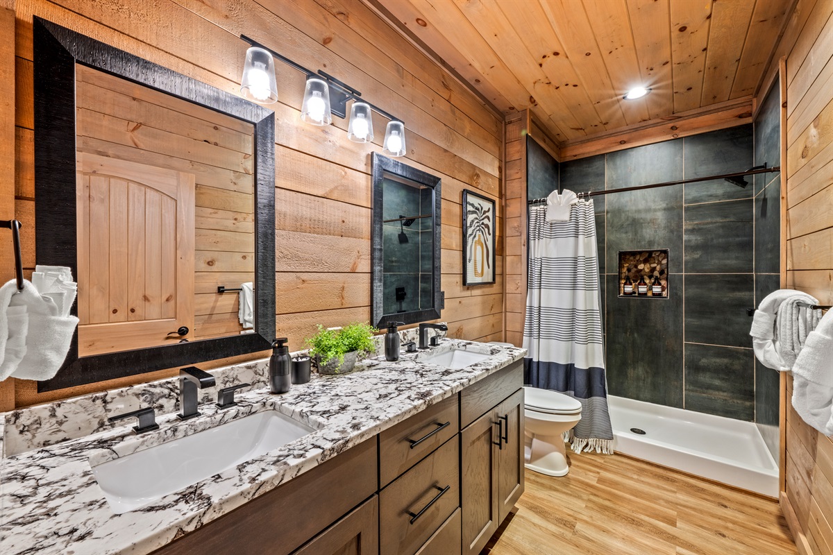 🛁 Luxury meets rustic charm. Double vanities, spa-worthy tile, and all the fluffy towels your crew could want. (Main Level, Shared)
