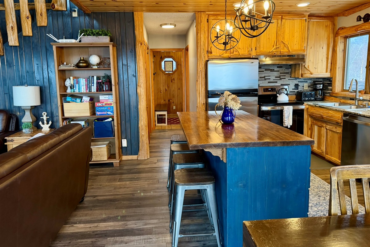 Step back in from the deck to a cozy hangout, with board games on the  shelf ready to play, the kitchen right there, and a warm, fun space to relax and reconnect after a day exploring the North Shore.