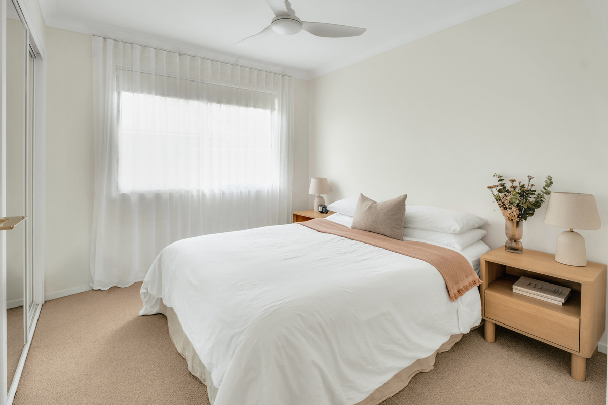 Rest and recharge in this peaceful bedroom, complete with a ceiling fan and built-in mirrored wardrobe.