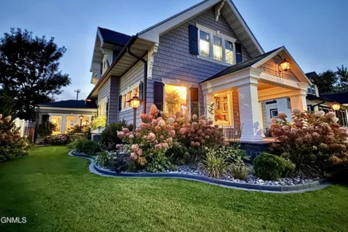 A welcoming front view with colorful flowers and a well-kept yard.
