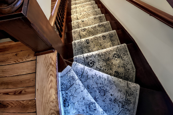Original historic staircase is carpeted and well lit