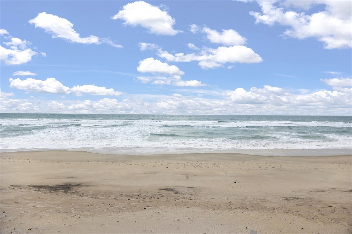 Relax in the backyard with a stunning ocean view, where soft white sand meets the shimmering waters, offering a peaceful and scenic retreat right in front of the ocean.