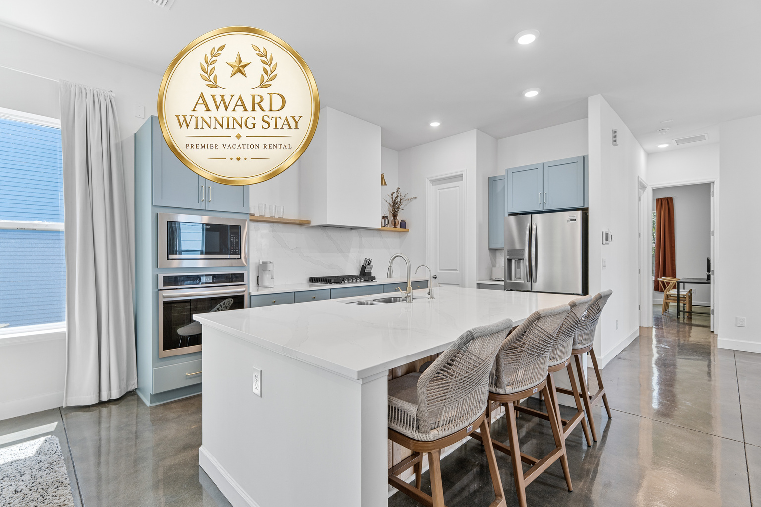 Gather around the island while someone flips pancakes and the coffee goes on. With seating for four and room for helpers, this is where your mornings start slow and your evenings run long, everyone talking over everyone else.