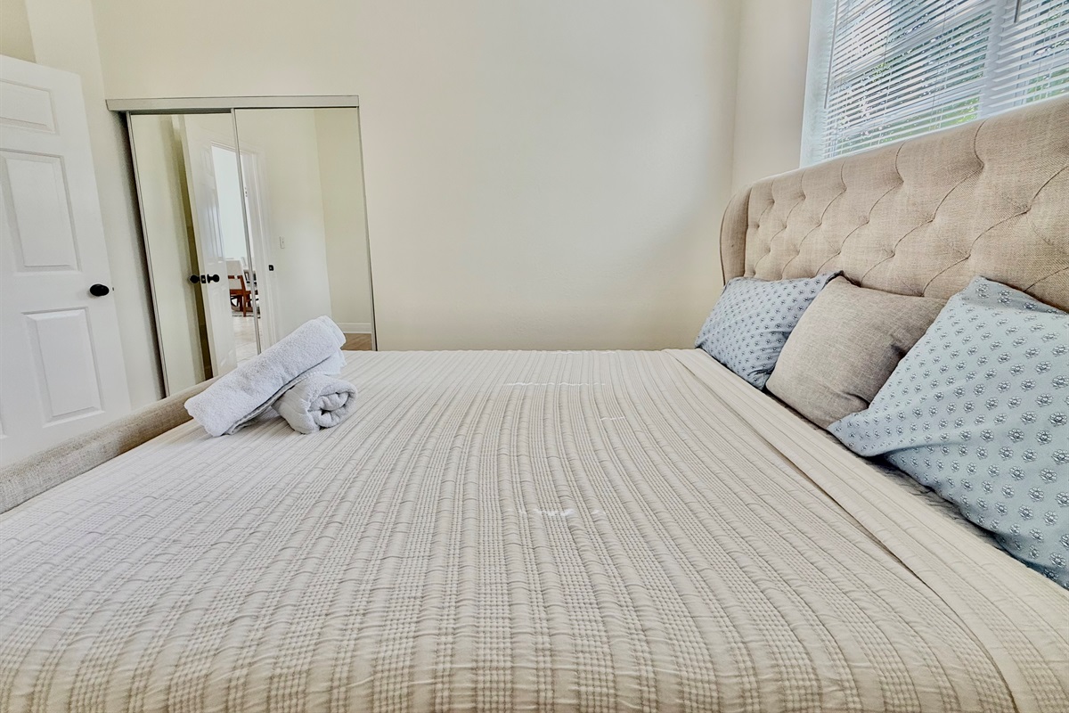 A sophisticated upholstered bed anchors this peaceful retreat—ideal for curling up with a book or getting a great night’s sleep.