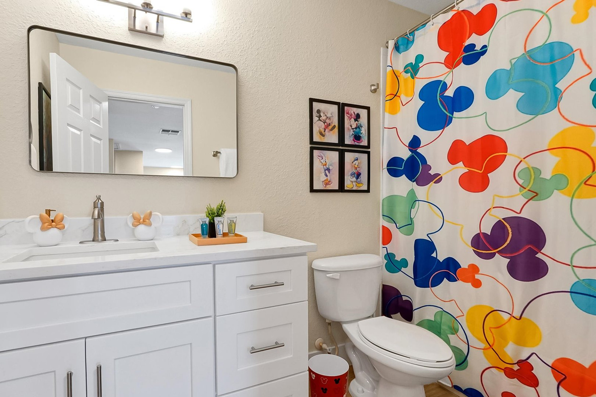Mickey’s Rainbow Magic Bathroom – Full bathroom with a spacious vanity and shower-and-tub combination