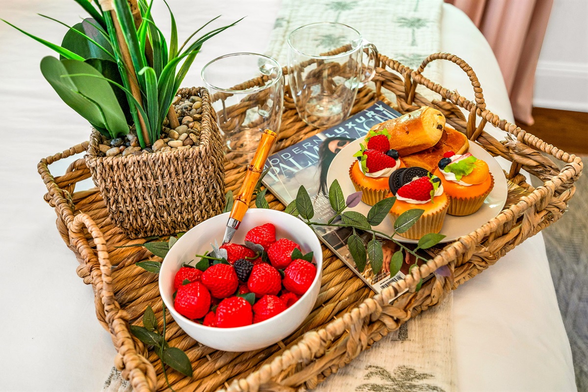 Primary bedroom with a king bed, smart TV, and ensuite bath featuring an antique soaking tub and modern shower. Cane rattan headboard, blackout drapes, and Palm Beach art add charm. Opens to the 4th bedroom, ideal for a private family suite.