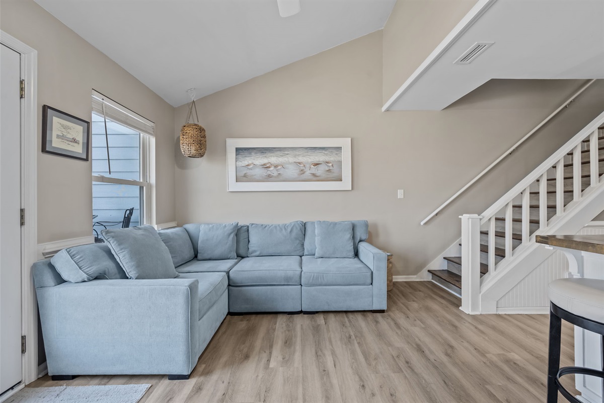Relax in the bright coastal living area with a spacious sectional &mdash; the perfect spot to unwind after a day at the beach