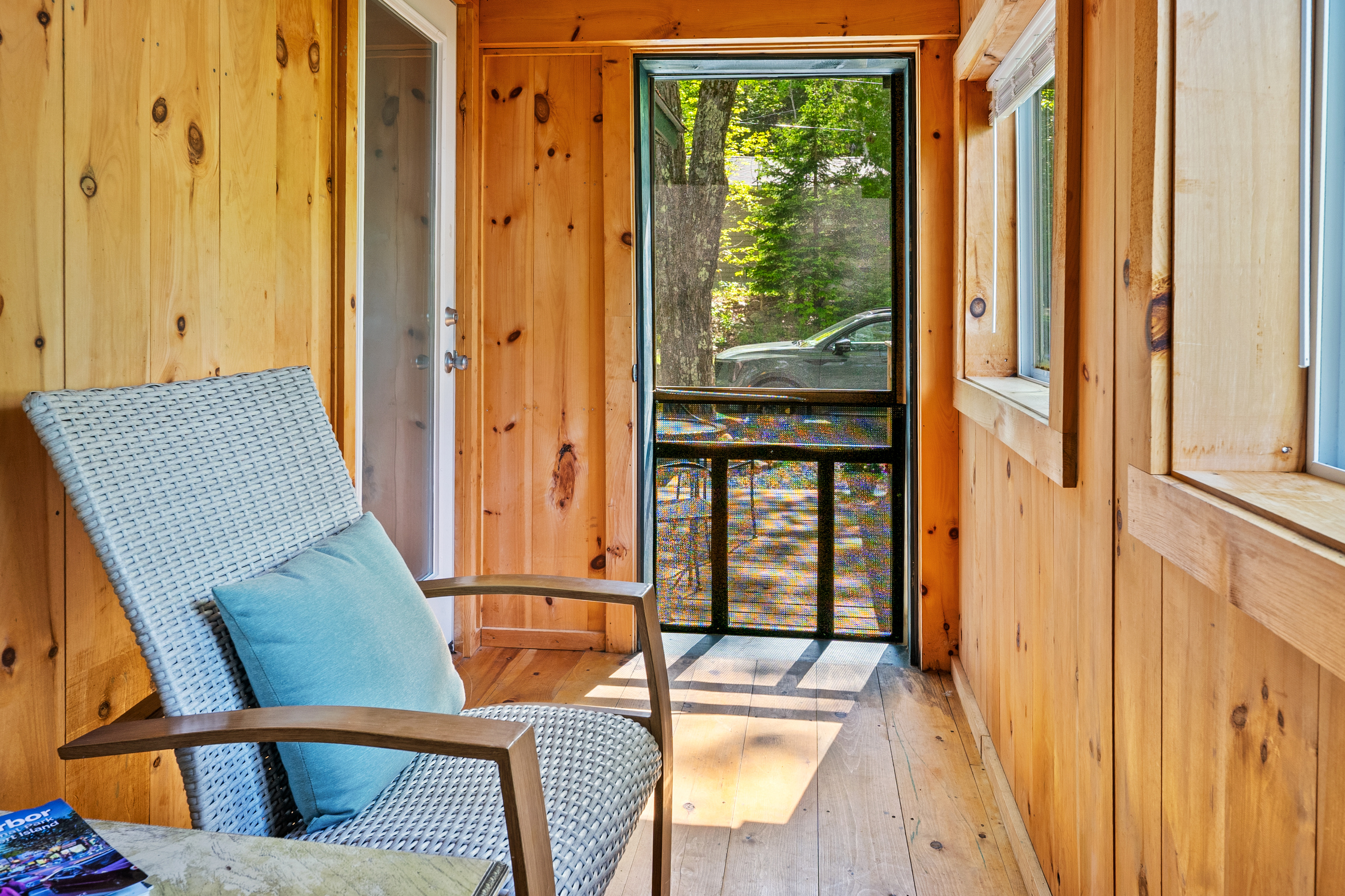 The Pine Breeze Room, viewed from the far seating end. See how it effortlessly connects the main cabin interior to the outdoor deck through dual convenient doorways. A bright, pet-friendly transition zone to gear up or wind down at the Outpost.