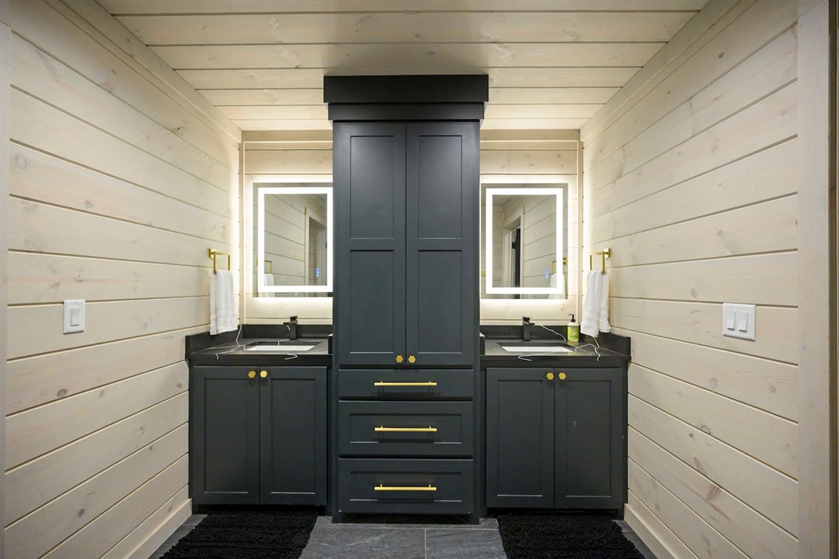 The gorgeous double vanity in the downstairs bathroom offers a ton of storage and modern back lit mirrors.