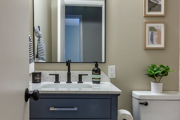 A moody navy vanity and matte black fixtures add a touch of understated style to your routine.
