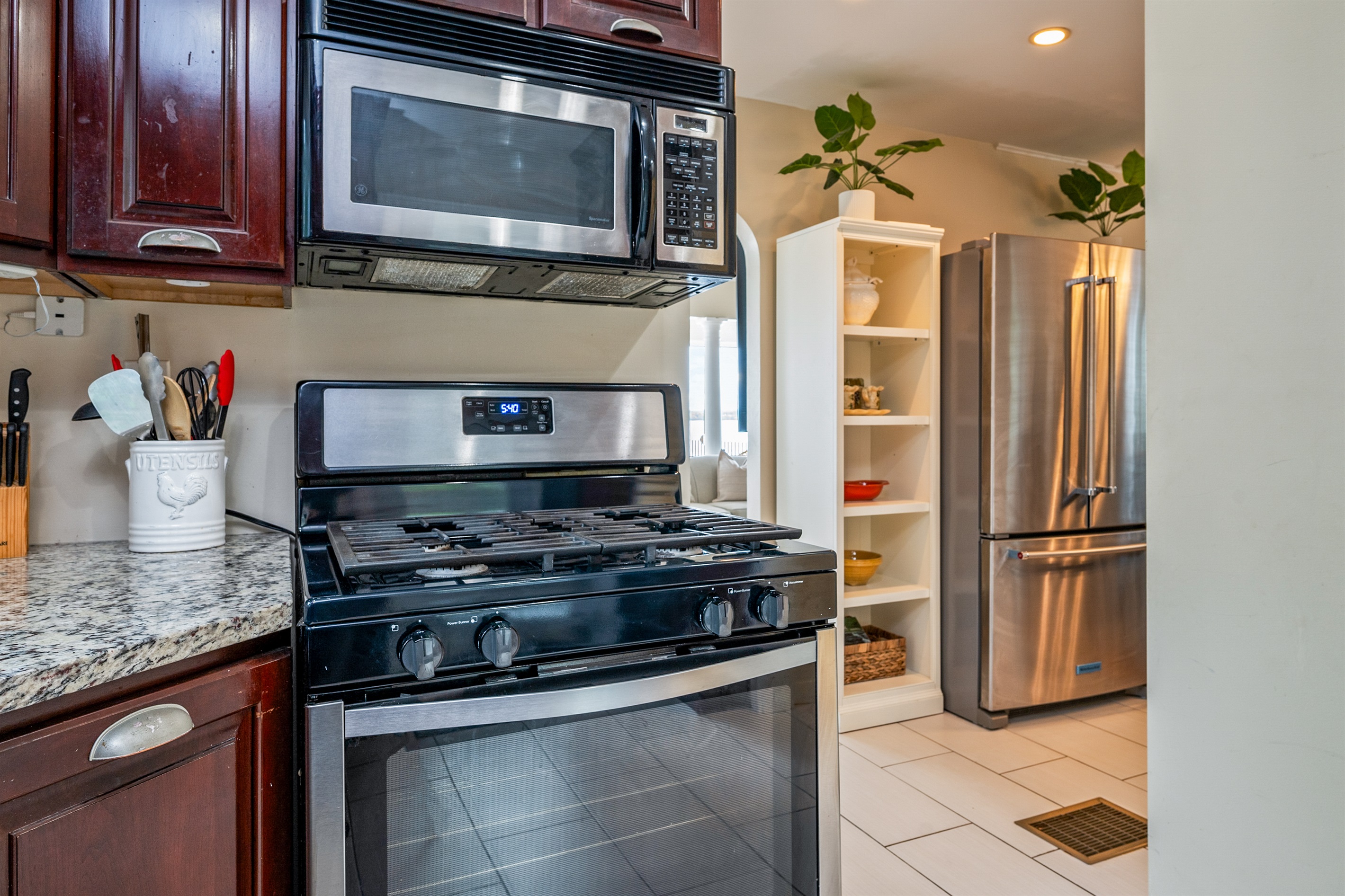 Cook with ease in a well-equipped kitchen featuring rich wood cabinetry and modern appliances 🍳☕🔪