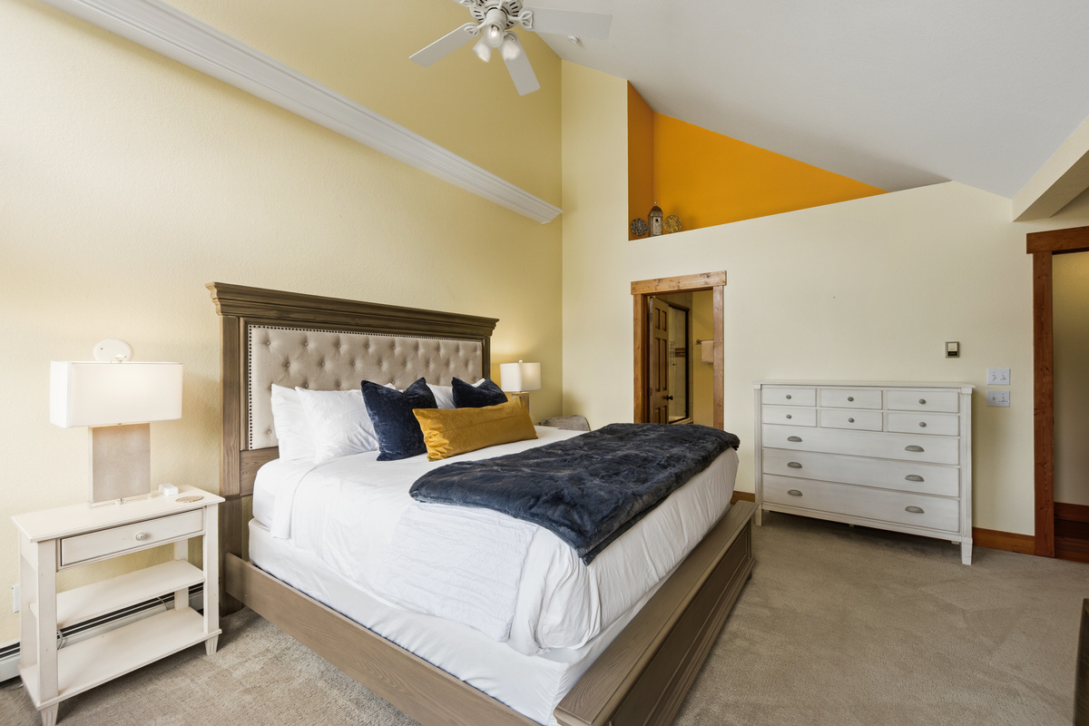 Oversized Primary King bedroom with vaulted ceilings and attached full bathroom. The twin size cot stored in the large walk-in closet fits easily into this space. 