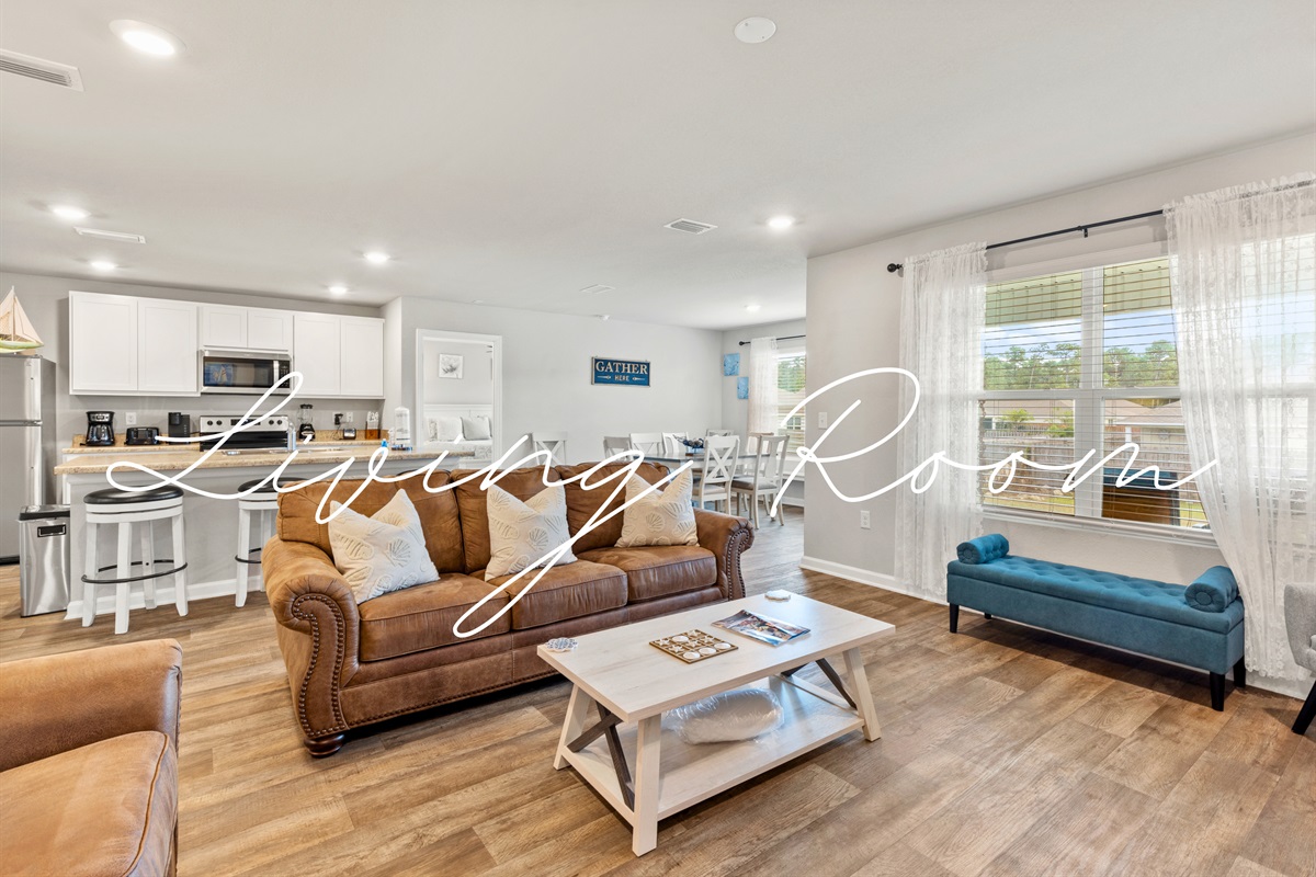 Comfortable living room featuring coastal art, warm lighting, and space for everyone to gather.
