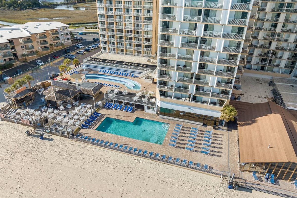 Aerial view of pool deck, Ocean Annies beach bar, and the lazy river. 