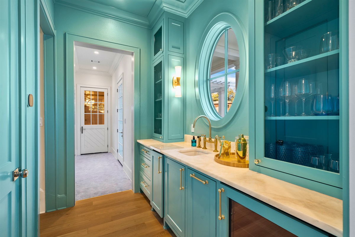 Bright teal chef's kitchen stocked with all you could need for a fun drink.