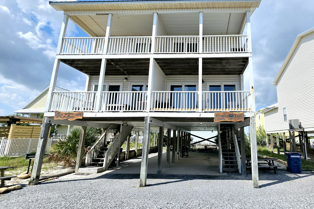 The duplex from the front, with parking and stairs under each side