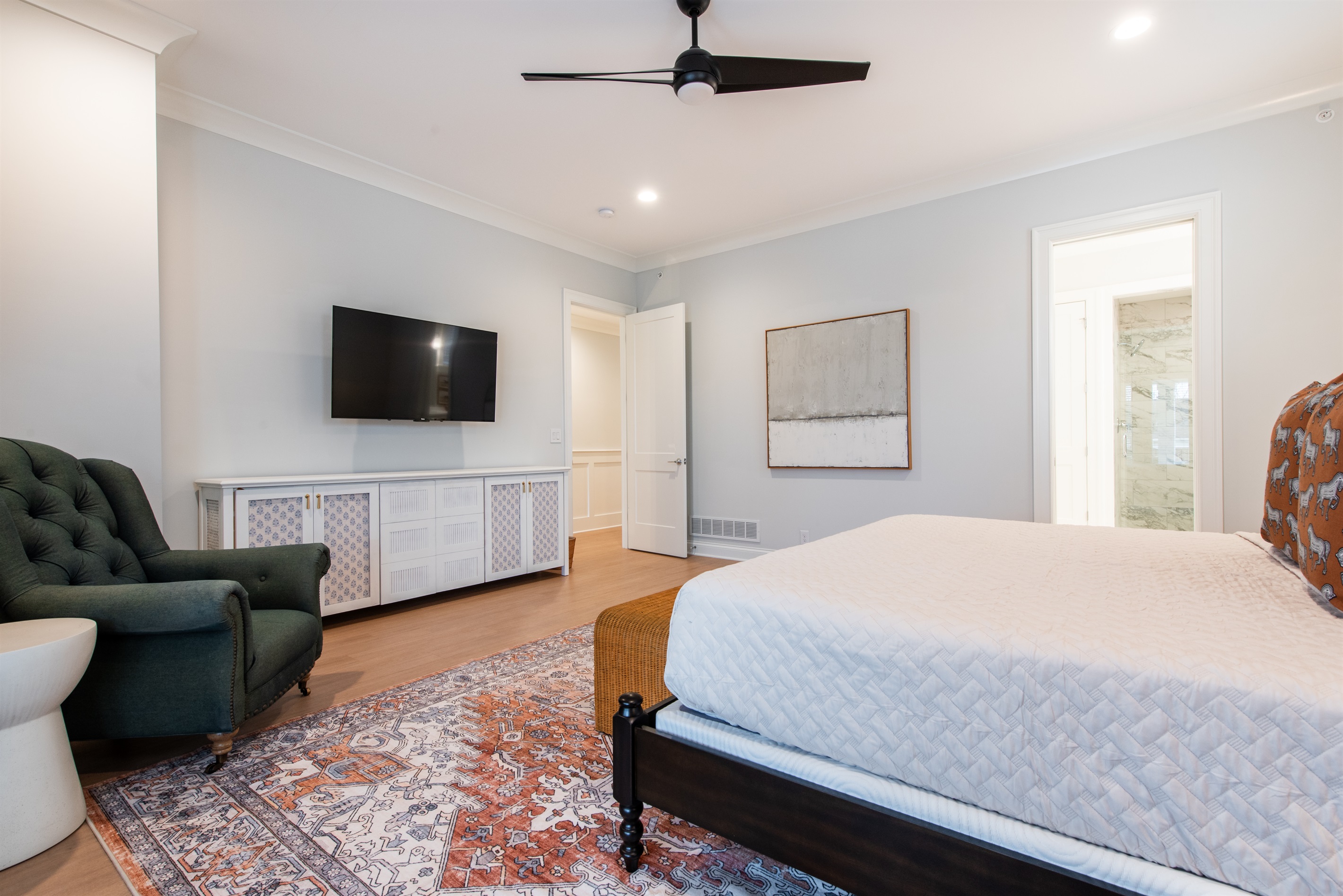 This bedroom offers a king-sized bed enveloped in plush linens, a cozy tufted armchair, and access to a private balcony for your bourbon evenings. 