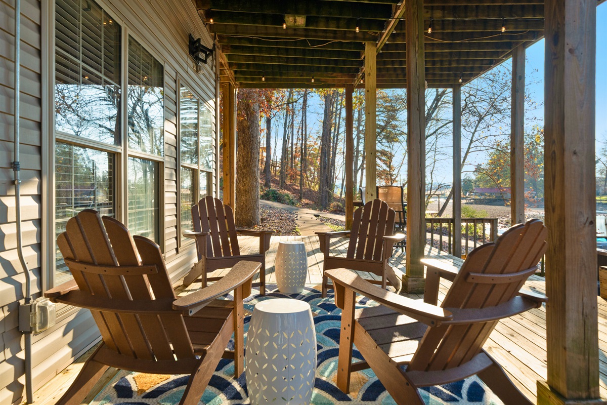 The shaded seating beneath the deck provides a cool escape during warm afternoons, offering a quiet spot to relax with a drink or a book.
