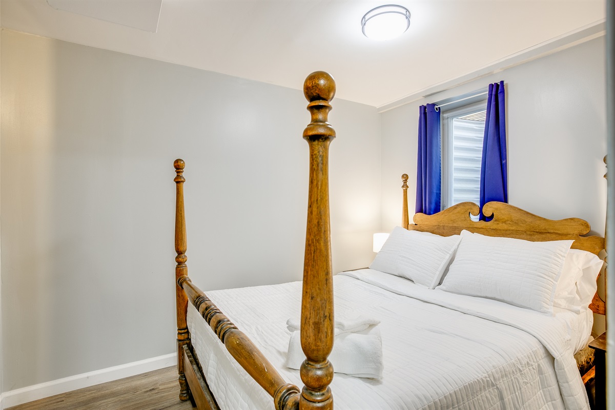 Basement double bedroom with mounted TV.