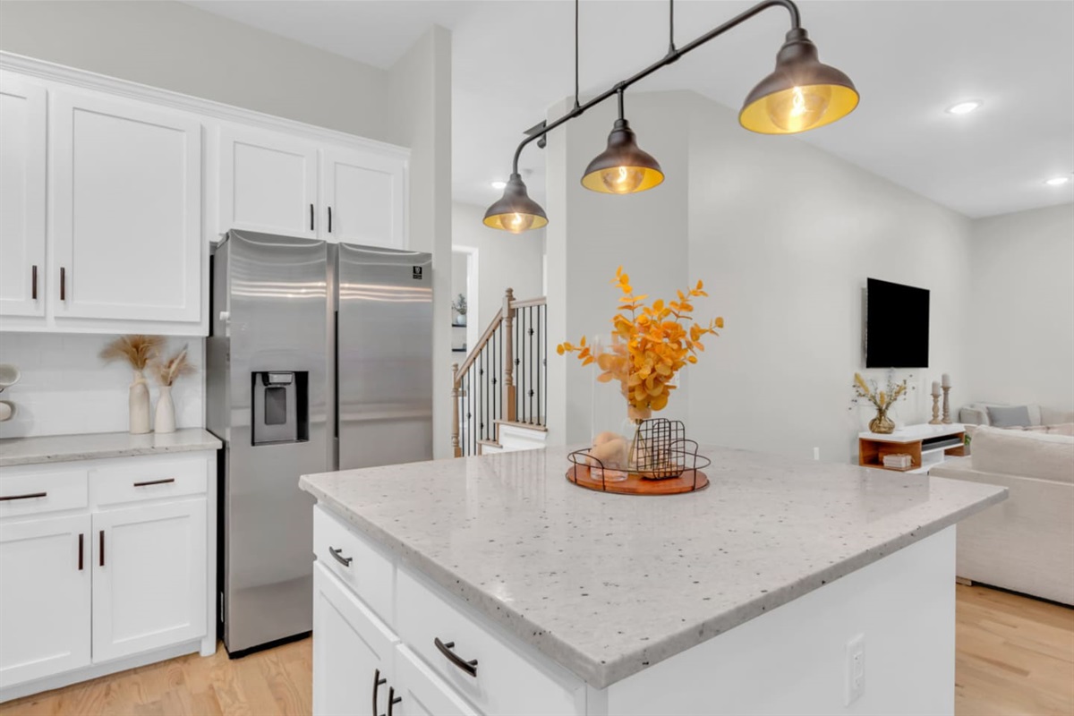 Chef’s kitchen with large island and sleek white cabinetry.