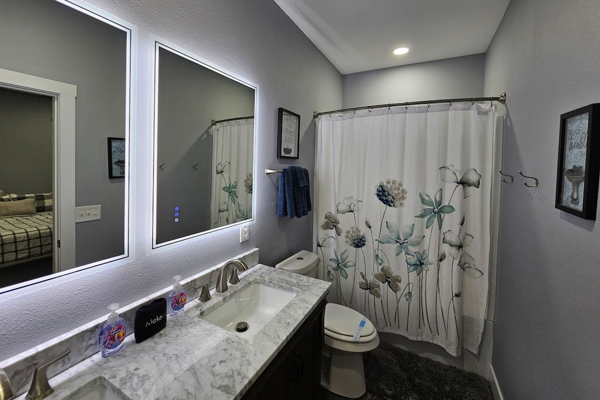 Clean and inviting bathroom with full tub, fresh linens, and plenty of lighting.