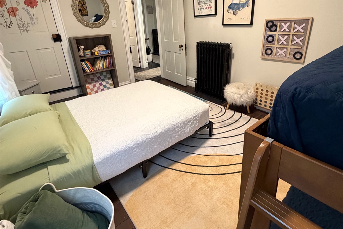 Sun filled family bedroom with full size bed, bunk beds, and fun artwork