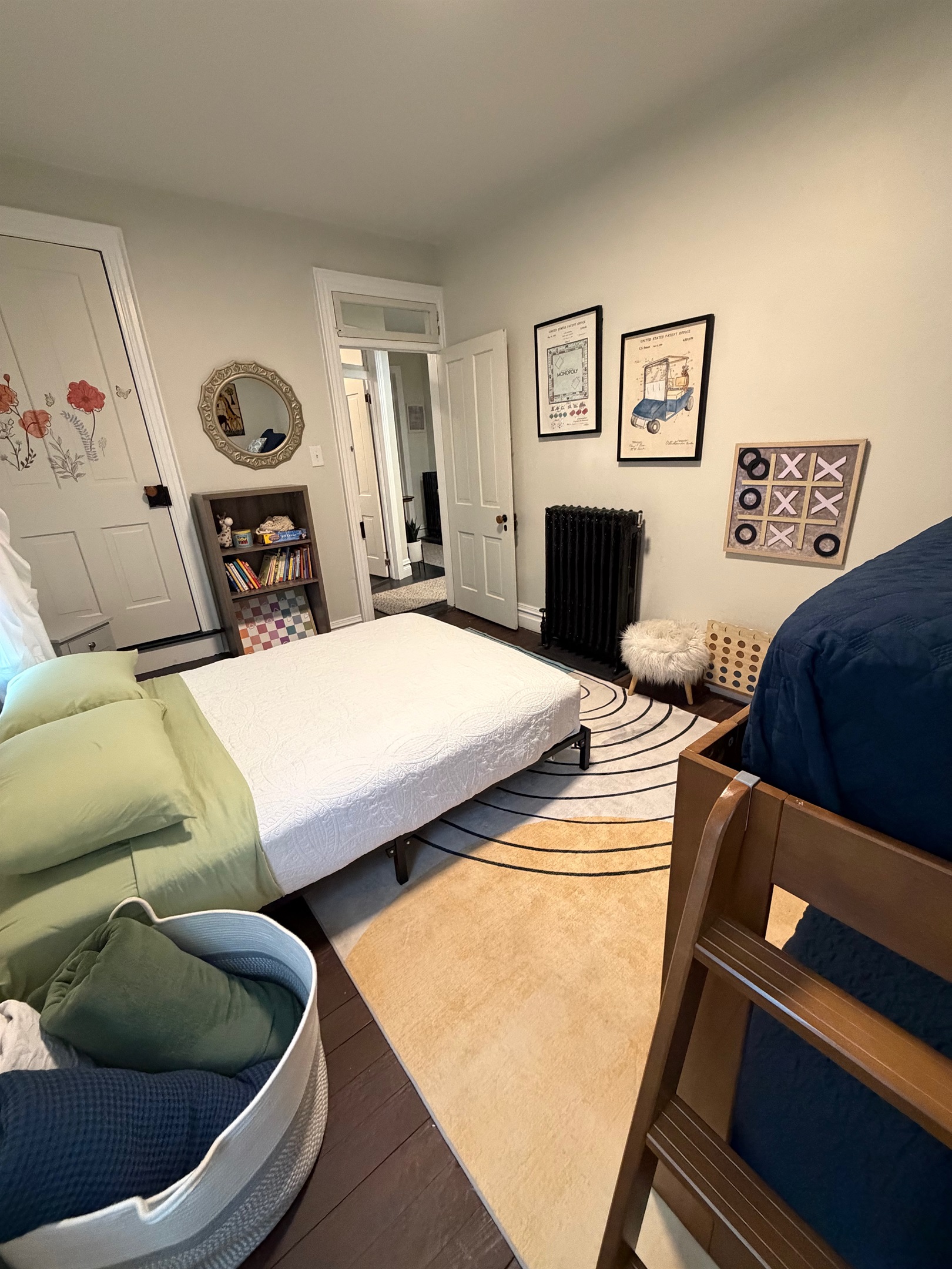 Sun filled family bedroom with full size bed, bunk beds, and fun artwork