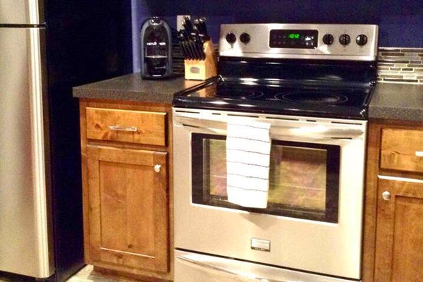 Stainless steel Microwave with range light and vent hood over the Whirlpool Profile series Convection oven. 
