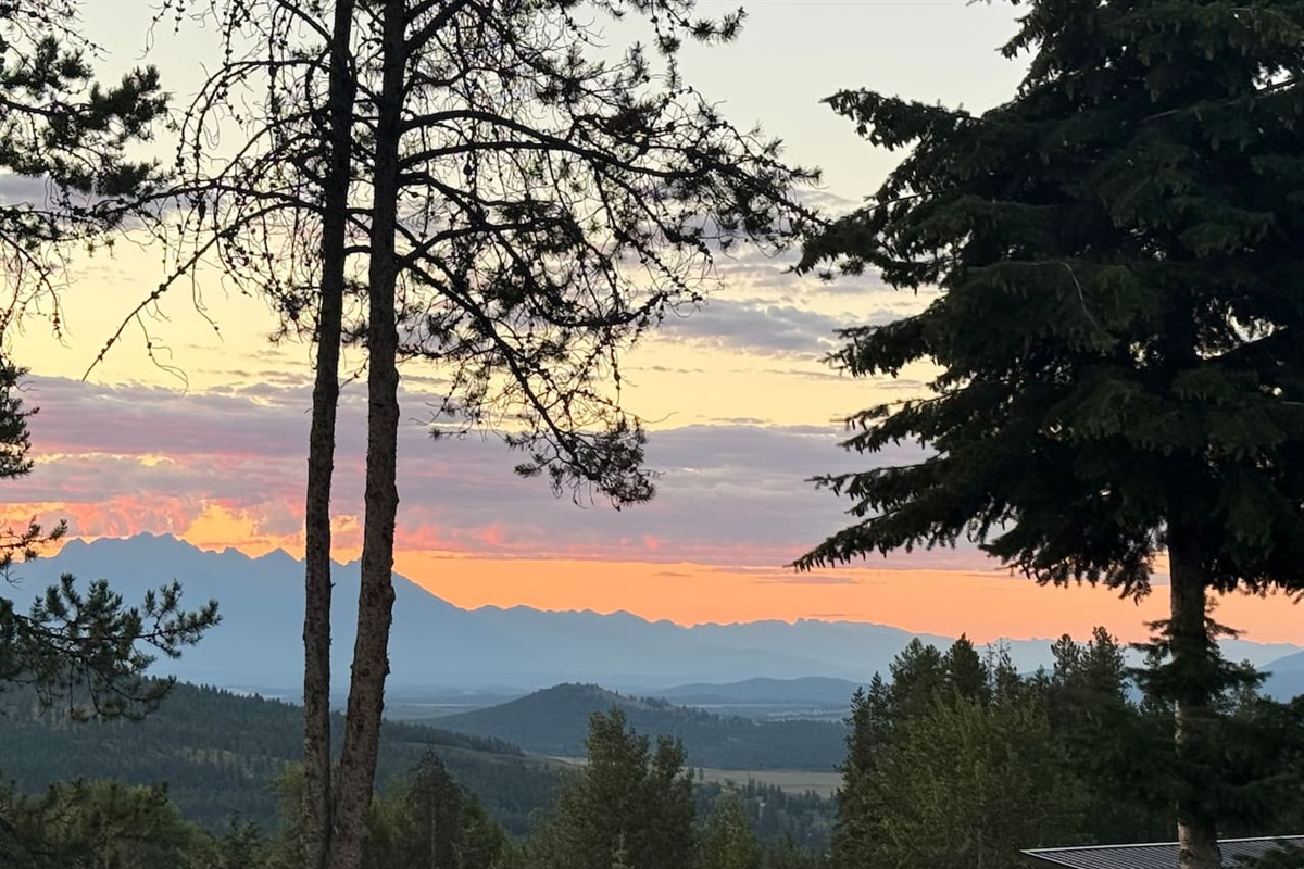 Mountain Panorama: A breathtaking east-facing view from the private deck overlooking the Rocky Mountain range during a golden sunrise.